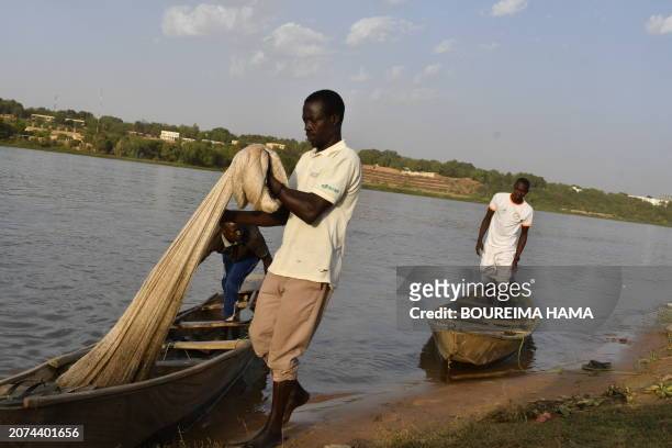 Fishermen from the island of Néni-Goungou prepare their nets to fish on the Niger River in Niamey on February 27, 2024. 4,200 km long, Niger supports...
