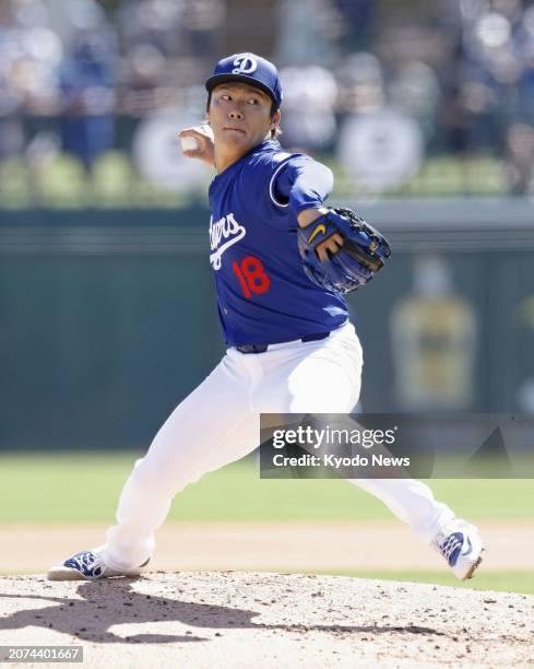 Yoshinobu Yamamoto of the Los Angeles Dodgers pitches in a spring training baseball game against the Seattle Mariners in Glendale, Arizona, on March...