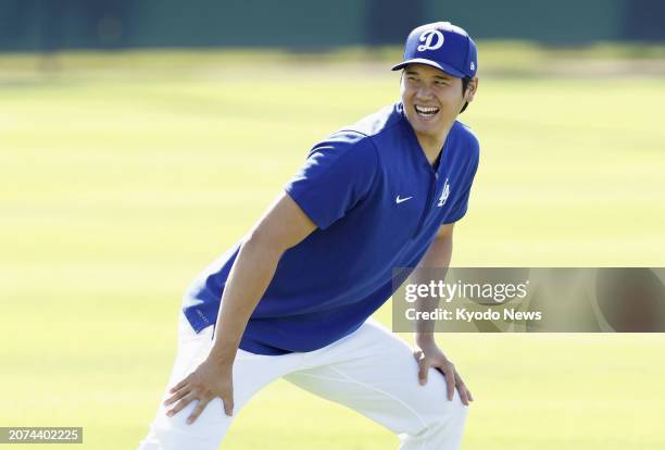 Shohei Ohtani of the Los Angeles Dodgers warms up ahead of a spring training baseball game against the Seattle Mariners in Glendale, Arizona, on...