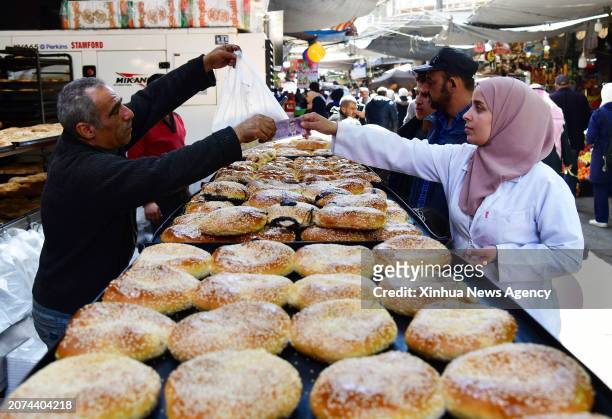 People shop for Maarouk sweets, delicate treats specifically made for Ramadan, in Damascus, Syria, on March 13, 2024.