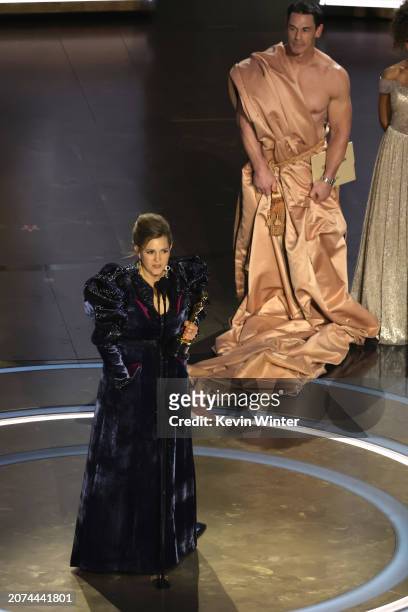 Holly Waddington accepts the Best Costume Design award for "Poor Things" from John Cena onstage during the 96th Annual Academy Awards at Dolby...