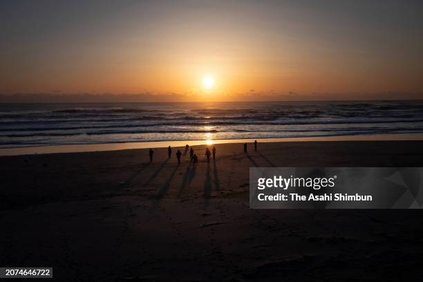 People watch the sunrise at Usuiso beach on the 13th anniversary of the Great East Japan Earthquake on March 11, 2024 in Iwaki, Fukushima, Japan....