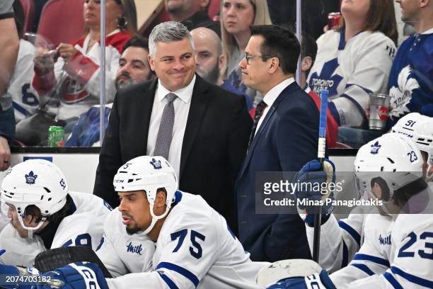 Head coach of the Toronto Maple Leafs Sheldon Keefe smiles at assistant coach Guy Boucher during the third period against the Montreal Canadiens at...