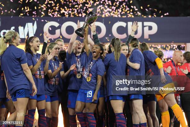 Crystal Dunn lifts the championship trophy as she celebrates with teammates after defeating Brazil during the 2024 Concacaf W Gold Cup final at...