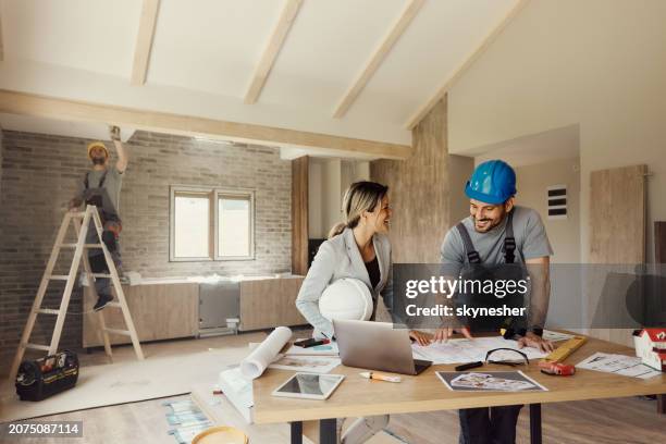 happy inspector and manual worker talking about housing plans during renovation process. - building contractor stock pictures, royalty-free photos & images