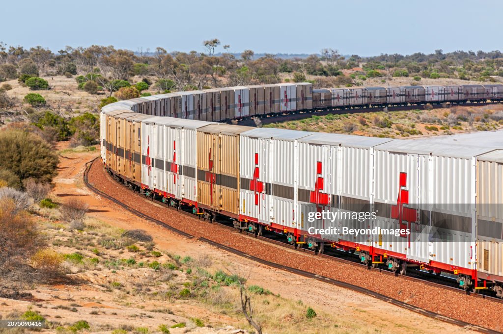 SCT freight train skirting round a dry Lake Hart in remote South Australian outback