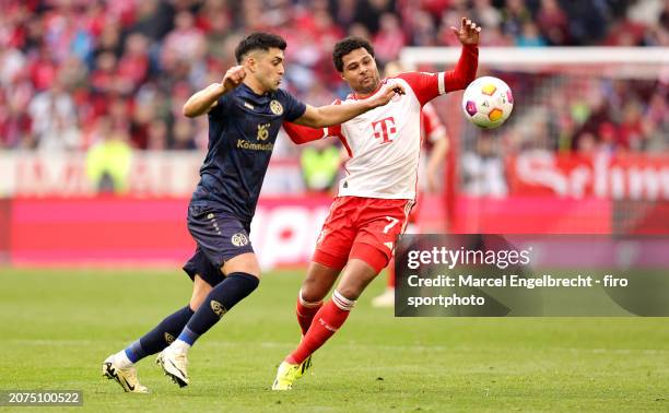 Nadiem Amiri of 1. FSV Mainz 05 and Serge Gnabry of FC Bayern München compete for the ball during the Bundesliga match between FC Bayern München and...