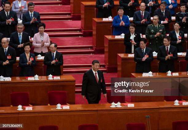 Chinese President Xi Jinping, centre, is applauded as he arrives at the closing session of the NPC, or National Peoples Congress at the Great Hall of...