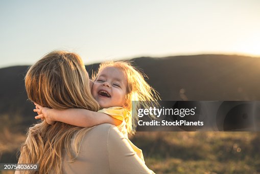 Happy girl kid hugging mom in the nature Happy girl kid hugging mom in the nature