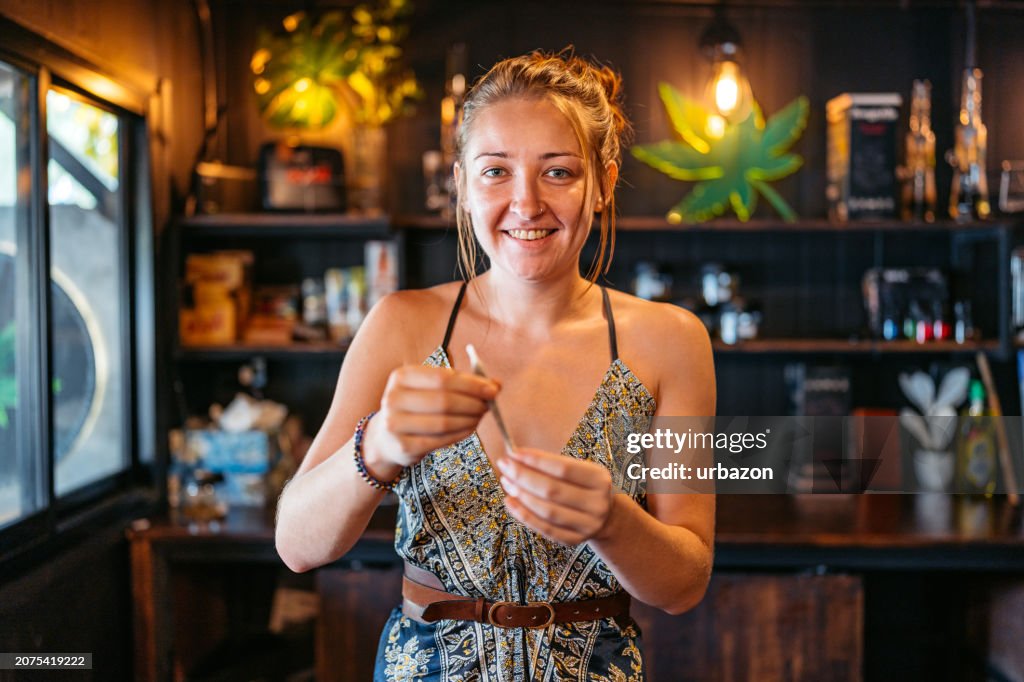 Young Woman Making A Marijuana Joint In A Cannabis Shop In Thailand