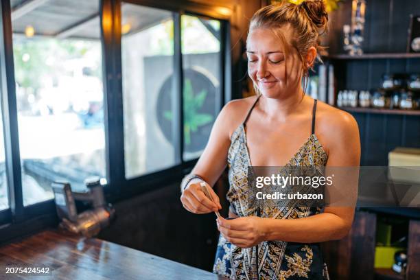 young woman making a marijuana joint in a cannabis shop in thailand - a j price stock pictures, royalty-free photos & images