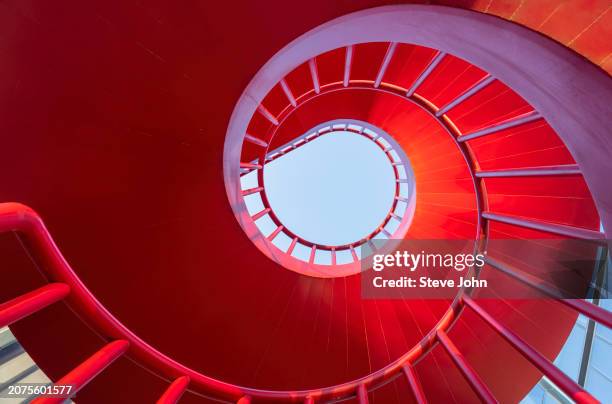 spiral red metal staircase in business district - curve stock pictures, royalty-free photos & images