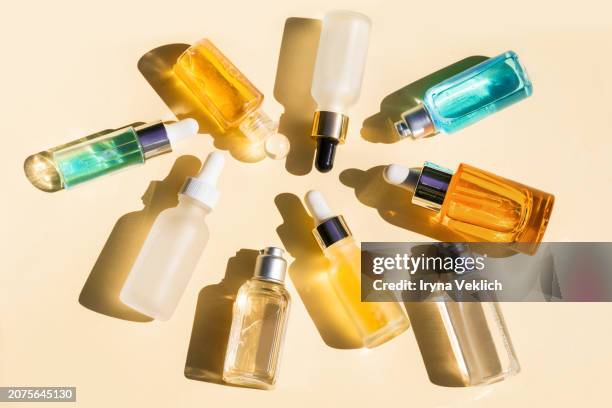 collection of natural cosmetics and liquids of beauty products for body and face care in glass bottles with pipette and shadow on pastel peach color background. - ampoule dessin stockfoto's en -beelden