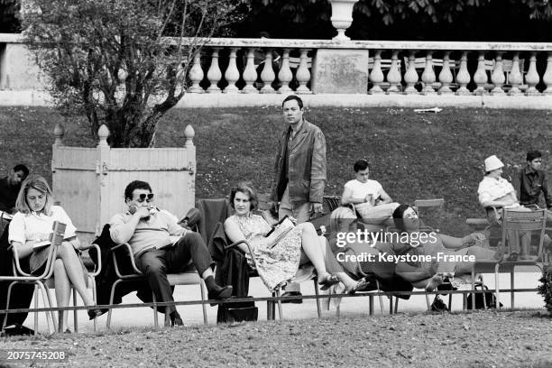 Parisiens profitant du soleil sur les chaises du jardin des Tuileries à Paris, le 11 mai 1964.