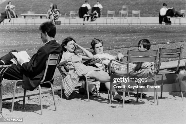 Parisiens profitant du soleil sur les chaises du jardin des Tuileries à Paris, le 11 mai 1964.