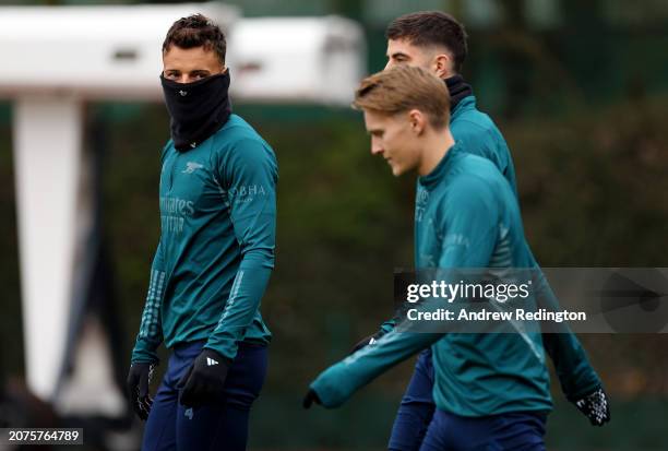 Ben White of Arsenal looks on as he walks onto the pitch with teammates Kai Havertz and Martin Odegaard prior to the Arsenal FC Training Session And...