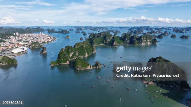 aerial drone sunset scene limestone cliffs and mountains with cityscape of ha long city, vietnam - hanoi cityscape stock pictures, royalty-free photos & images