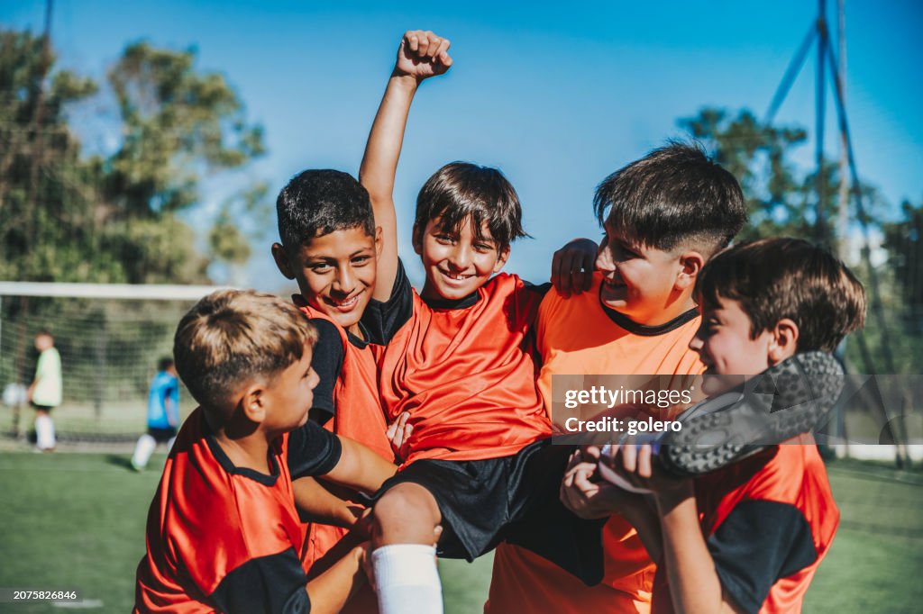 Cinque ragazzi di calcio che esultano dopo aver segnato un gol