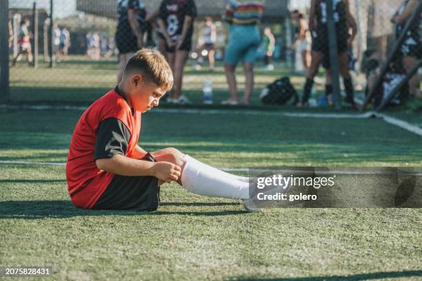 soccer boy rolling up socks  after match - championship final round stock pictures, royalty-free photos & images