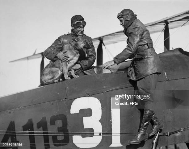 American aircraft mechanic William Kline and American aviator Belvin Maynard with their mascot, Trixie, on their de Havilland aircraft in which they...