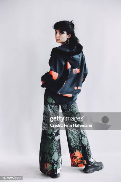 young woman stands with her back to the camera and looks over her left shoulder - flare pants stock pictures, royalty-free photos & images