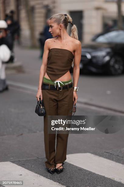 Caro Daur seen wearing brown sunglasses, a Miu Miu brown strapless top with matching Miu Miu brown pants with a black leather belt, Miu Miu green...