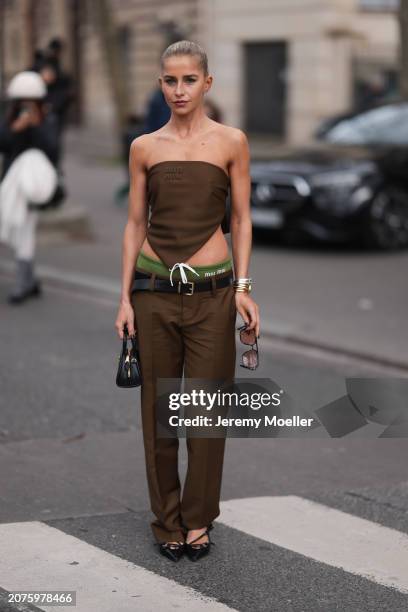 Caro Daur seen wearing brown sunglasses, a Miu Miu brown strapless top with matching Miu Miu brown pants with a black leather belt, Miu Miu green...