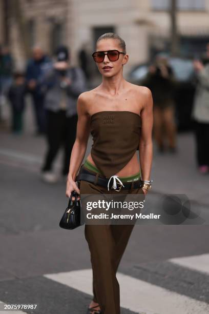 Caro Daur seen wearing brown sunglasses, a Miu Miu brown strapless top with matching Miu Miu brown pants with a black leather belt, Miu Miu green...