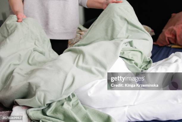 changing bedsheets - manta-ropa-de-cama fotografías e imágenes de stock