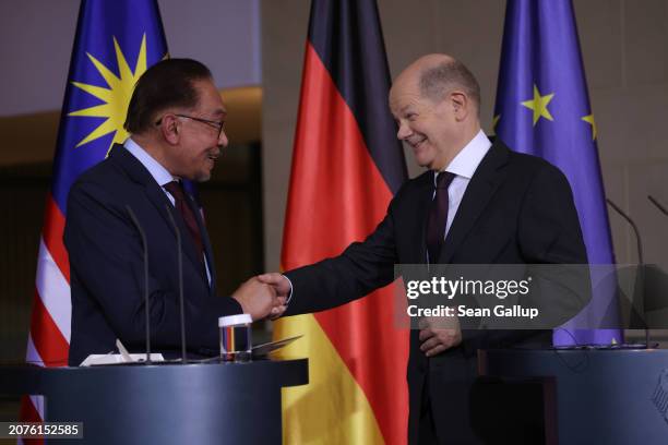 German Chancellor Olaf Scholz and Malaysian Prime Minister Anwar Ibrahim shake hands after speaking to the media during talks at the Chancellery on...