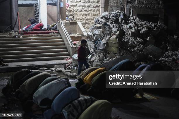 March 11: Palestinian citizens perform Tarawih prayers on the first day of the holy month of Ramadan on the rubble of Al-Huda Mosque, which was...