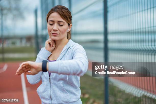 woman measures pulse on court - taking pulse stock pictures, royalty-free photos & images