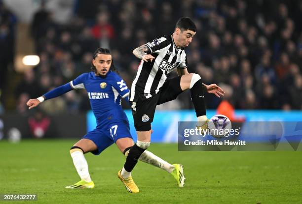 Miguel Almiron of Newcastle United holds the ball whilst under pressure from Malo Gusto of Chelsea during the Premier League match between Chelsea FC...