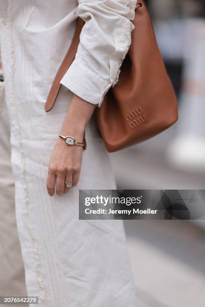 Claire Rose Cliteur seen wearing Miu Miu brown leather bag, brown sunglasses, white long blouse and white/cream straight leg pants outside Miu Miu...