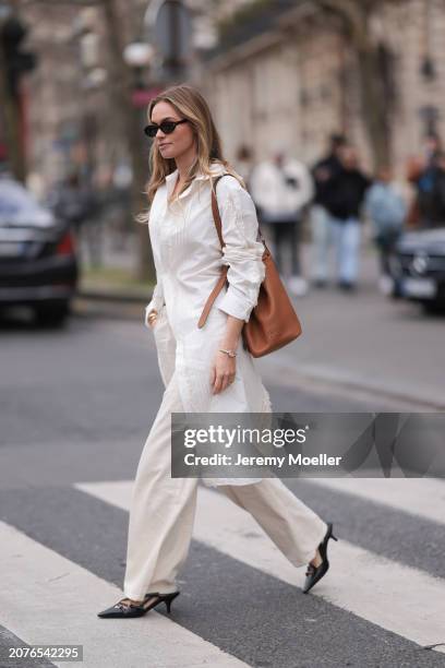 Claire Rose Cliteur seen wearing Miu Miu brown leather bag, brown sunglasses, white long blouse, white/cream straight leg pants and black leather...