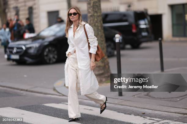 Claire Rose Cliteur seen wearing Miu Miu brown leather bag, brown sunglasses, white long blouse, white/cream straight leg pants and black leather...