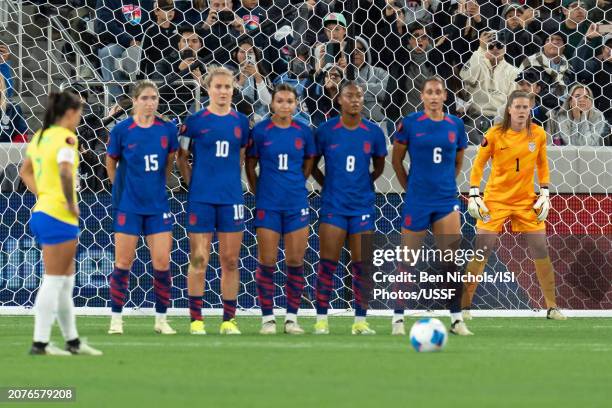 Alyssa Naeher of United States peers around her wall of Korbin Albert, Lyndsey Horan, Sophia Smith, Jaedyn Shaw, and Lynn Williams while defending...