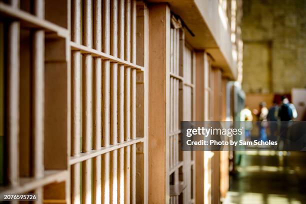 through the prison cell bars at alcatraz - cellule de prison photos et images de collection