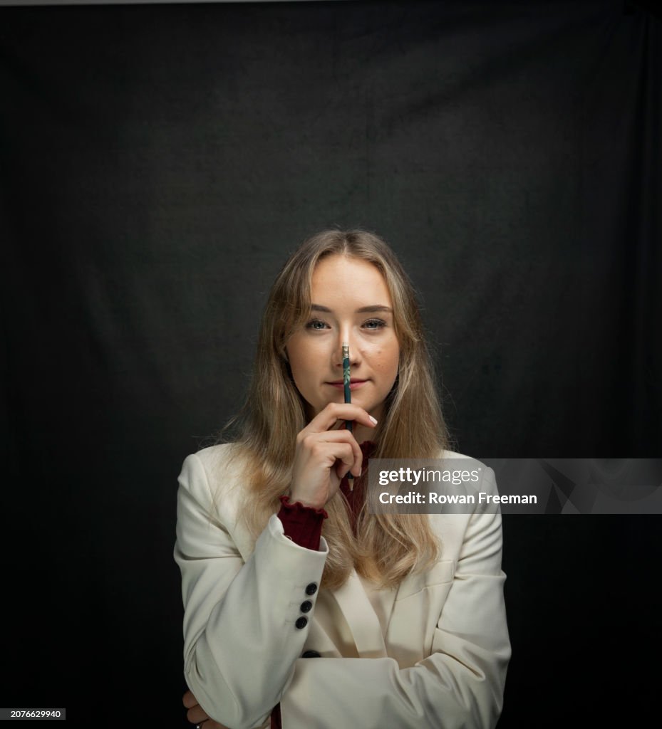 Thoughtful young woman entrepreneur with hand on chin