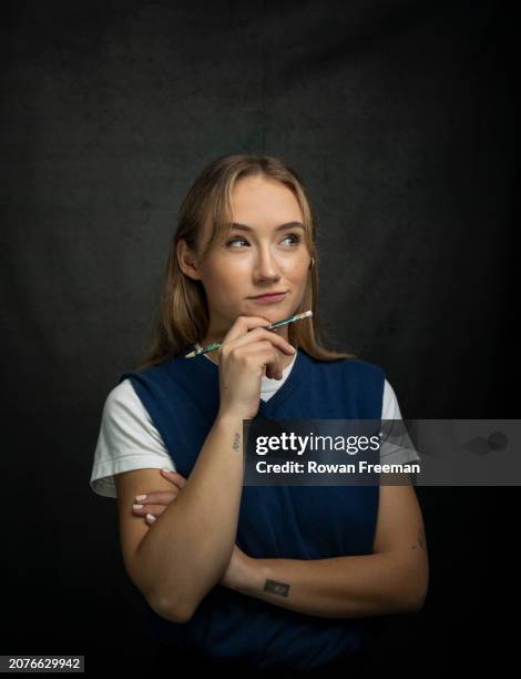 portrait of a thoughtful young woman with hand on chin - sleeveless sweater stock pictures, royalty-free photos & images