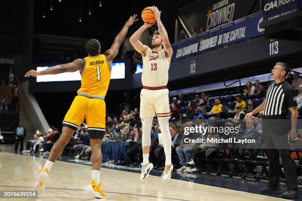 Ben Burnham of the Charleston Cougars takes a jump shot over Tomiwa Sulaiman of the Towson Tigers in the first half during the semifinal round of the...