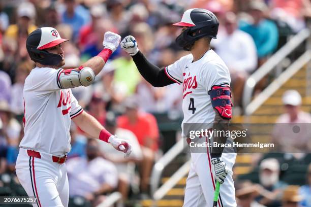 Edouard Julien of the Minnesota Twins celebrates with Carlos Correa during a spring training game against the Boston Red Sox on March 1, 2024 at the...