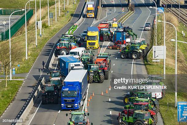 This aerial view taken on March 14, 2024 shows trucks and tractors blocking the entry to the Port of Antwerp-Brugesduring during a farmers' protest,...