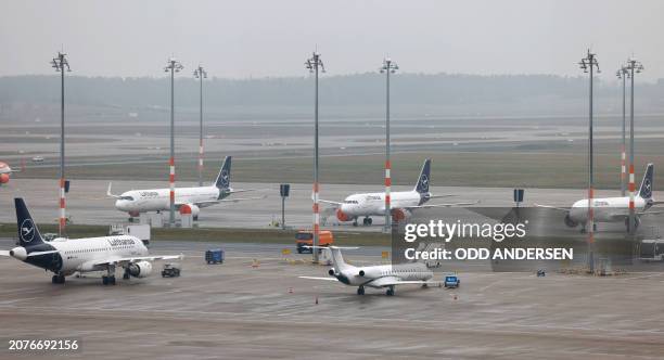 Lufthansa airplanes stand on the ground at the Berlin Brandenburg Airport in Schoenefeld near Berlin on March 14 as aviation security personnel went...