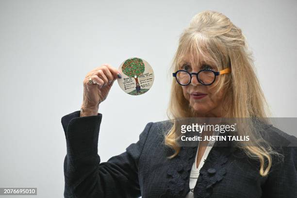 English model and photographer Pattie Boyd holds an original design doodle for an Apple records LP label by late English musician and Beatles member...