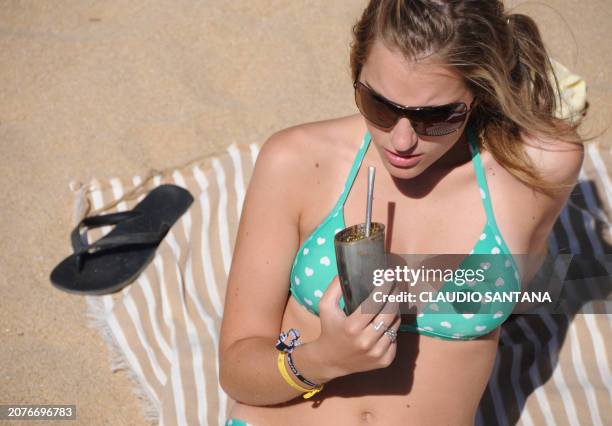 An Argentine tourist sips mate while sunbathing at Renaca Beach in Vina del Mar, Chile on January 15, 2009 .According to Chile's National Tourism...