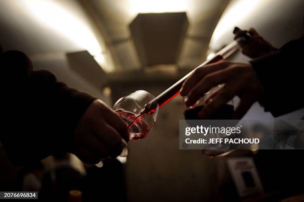 People prepare to taste wine in the "Nouvelle cuverie" of the Hospices de Beaune prior to their 150th charity auction wine sale, on November 21, 2010...