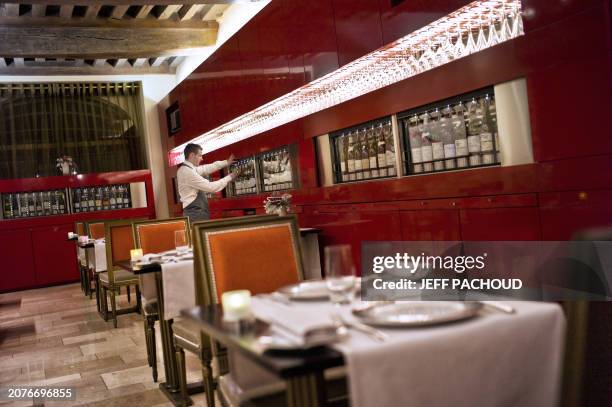 Cellarman serves a glass of wine for a customer in the Loiseau restaurant in Beaune, central France, on January 18, 2012. The glass of wine service,...