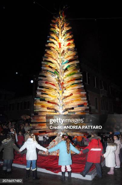 Picture taken 08 December 2006 shows children dancing around the biggest glass Christmas tree in the world, measuring 8,52m in the Campo Santo...