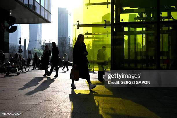 Pedestrians walk down the street during a sunny day in Warsaw, Poland on March 14, 2024.